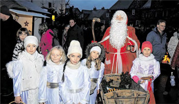 Der Nikolaus verteilt bei seinem Gang über den Markt mit seinen hilfreichen Engelchen Herzen aus Hefeteig. (WP-Foto: Lars-Peter Dickel)